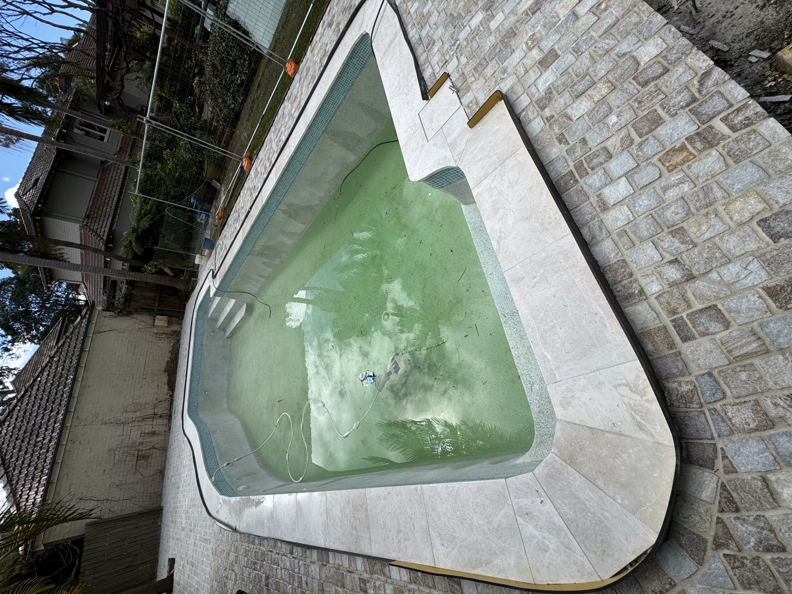Stone-tiled pool deck with cobblestone surrounds, Rong Xiang Tilers